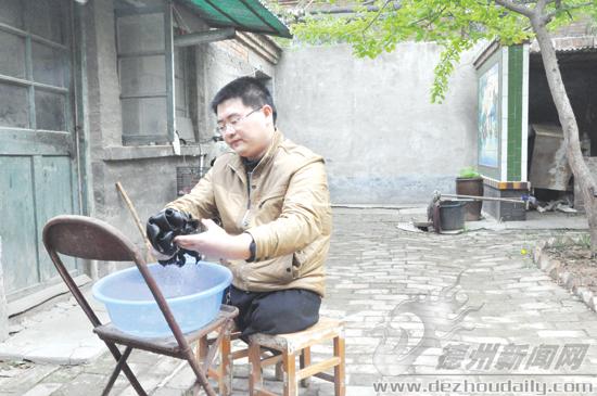 吳洪飛坐在凳子上洗衣服。記者 李靜 攝