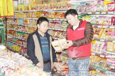 賈濱（左一）到超市了解經(jīng)營情況。